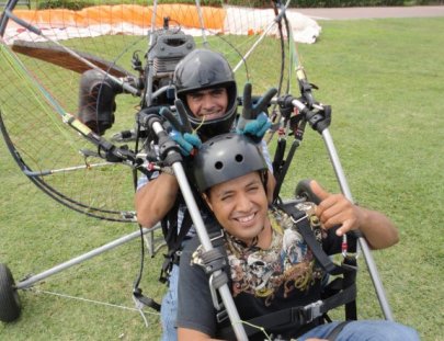 Action Valley-Paratrike over seawalls of green coast of Lima
